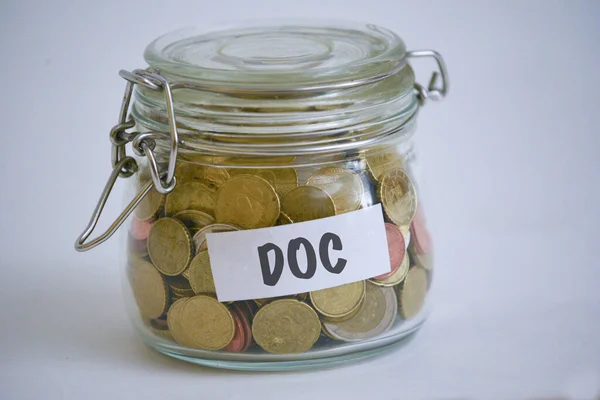 jar full of coins with a DOC sign on it