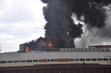 Yanan bina ve gri duman bulutları, yangınlarda zehirli baca gazı