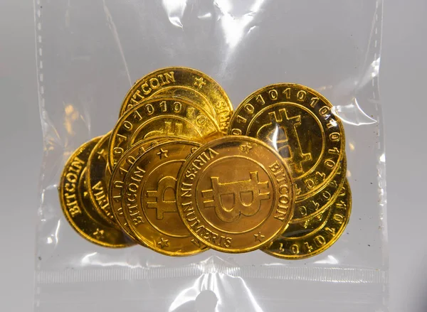 プラスチックの裏側にある黄金のビットコインは電子通貨を表し — ストック写真