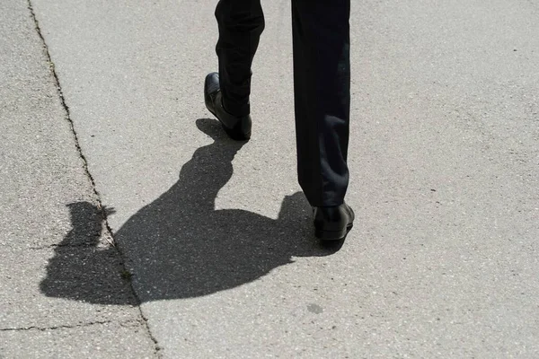 Takım elbiseli adam sokaklarda yürüyor, iş hayatında dinamik.