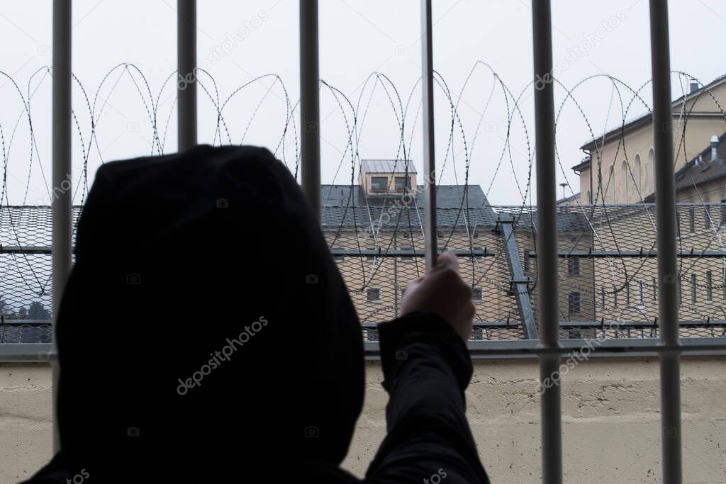 prisoner looking out of the window of a prison cell