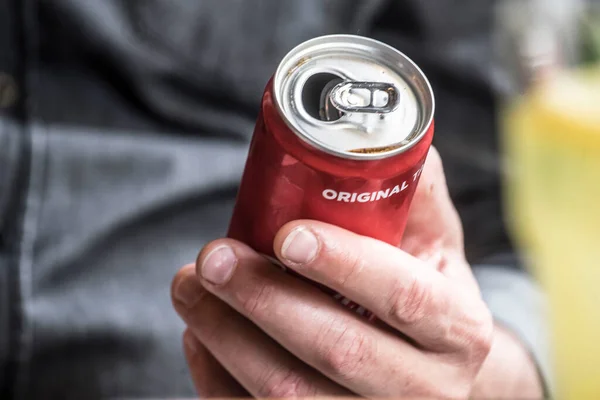 holding an opened beverage in an aluminum can in hand