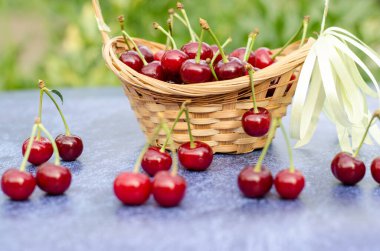 Ağaç bir sepetin içinde olgun, sulu bir kiraz. Bahçe işleri konsepti. Sağlıklı yemek..