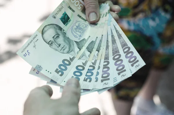 Bir kadın bir erkeğe para transfer eder. Yozlaşma kavramı. Resmi görevli rüşvet alıyor. Kadın Ukrayna 'nın Hryvnia' sını erkeğe aktarıyor