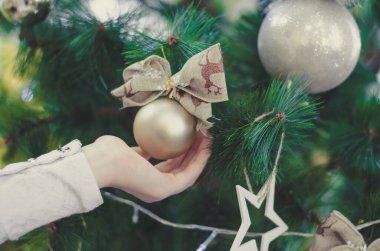 Bir çocuk Noel oyuncağına dokunur. Ağaçtaki süslemeler, seçici odaklanma. Noel tatili kavramı