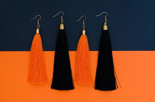 Kreatives Foto Von Schwarzen Und Orangefarbenen Quasten Ohrringen Weibliches Schönheitskonzept — Stockfoto