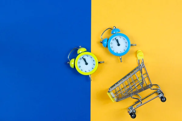 黄蓝色背景的时钟和购物篮 — 图库照片