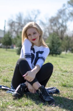 Genç, güzel, sarışın bir kadın. Parktaki fotoğraf.