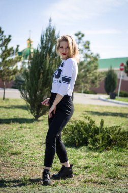 Doğada poz veren genç bir kız. Manken sarışın. Dikey fotoğraf