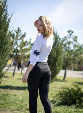 Doğada poz veren genç bir kız. Manken sarışın. Dikey fotoğraf