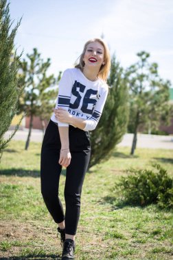 Doğada poz veren genç bir kız. Manken sarışın. Dikey fotoğraf