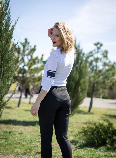 Doğada poz veren genç bir kız. Manken sarışın. Dikey fotoğraf