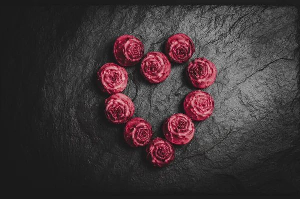 Червоні кекси у вигляді серця на чорному тлі. Серце з кексів . — стокове фото
