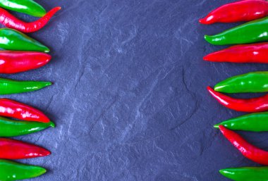 Taş zeminde kırmızı ve yeşil kırmızı biber. Mesaj için yer. Genel Görünüm