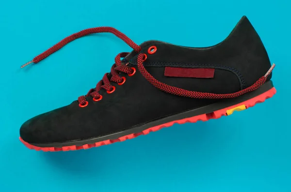黑色运动鞋 蓝色背景上有红色鞋带 时髦的青年运动鞋 — 图库照片