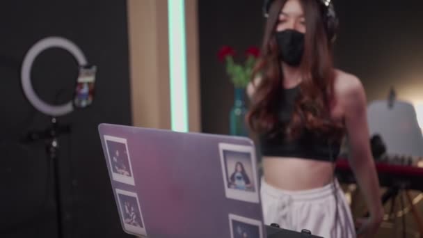 アジアの女性Djは黒のマスクを身に着けている夜のクラブで音楽を楽しみます Edm音楽パーティー ライブ演奏 アジアの女性Djミックス音楽 抗隔離Covid 独立した女性 インターネットライブストリーミング — ストック動画
