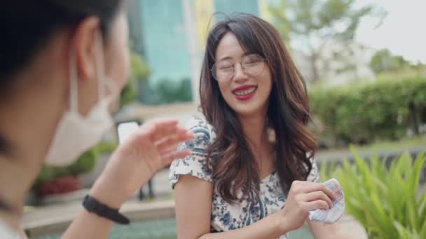 2人のアジアの女性の友人がコビド 反検疫新しい正常な生活様式の間に公園で互いに話します 2人のガールフレンドの間の候補者の会話 笑顔の女の子の話 ゆっくりとした動き — ストック動画