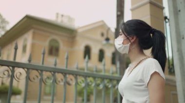 Koronavirüs kovid 19 'dan korunmak için Asyalı genç kadın maske takıyor.