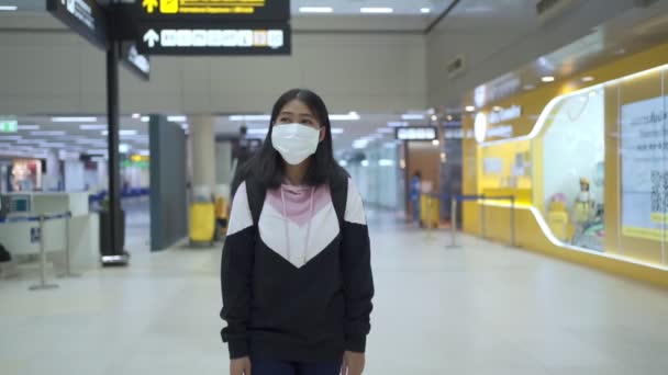 空港ターミナル出発ホールでキューイングラインを歩く保護医療マスクの若いタンスキンアジアの女性 家を出て旅行 コビド 19パンデミック 新しい正常な社会的距離 遅い動き — ストック動画