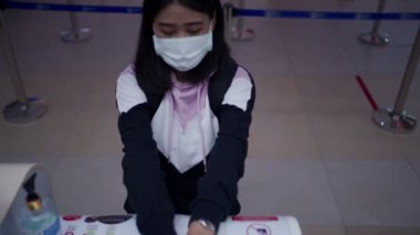 Genç Asyalı kadın havaalanında kredi kartı dağıtıyor. Terminal kalkış zamanı, boş havaalanı, covid-19 salgını, yeni normal sosyal mesafe, mutlu pozitif tutum Asyalı kadın.