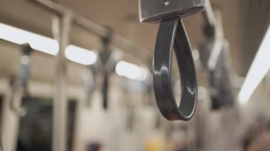 Asyalı bir kadının el ele tutuşması metro istasyonunda siyah koruyucu maske takması, metro treninde durması, virüs bulaşmış nesne, gökyüzü treninin içindeki normal bir kız, kendini koruması.