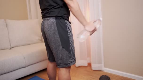 Homme Tenant Des Bouteilles Eau Plastique Faisant Squat Dans Salon — Video