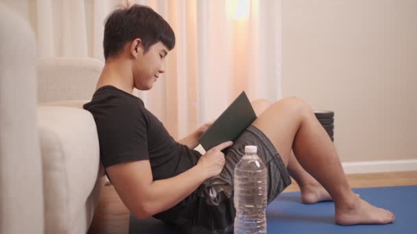 아시아인 청년은 앉아서 집에서 연습하고 열성적 아이는 잠그고 매트에 거실에서 — 비디오