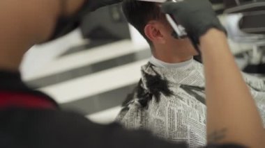 Berber dükkanında saçını kestiren Asyalı adam siyah koruyucu maske takıyor. İş fırsatı Profesyonel Berber. Corona virüsü sırasında insan sağlığı ve berber endüstrisi Codemic Covid-19 yeniden iş kurdu