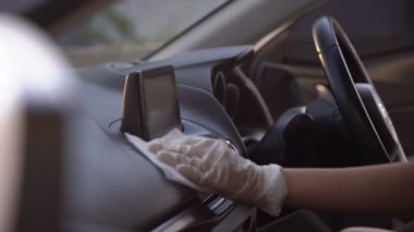 4K adamı arabasını dezenfekte eder, direksiyon simidini spreyler, el havlusu beyaz bez mendiller, salgın sırasında. Dezenfeksiyon ve sterilize etme, Covid-19 virüsü enfeksiyonunu önleme, mikrop bulaşmasını önleme