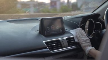 Beyaz eldiven el dezenfekte araba iç konsol panel, ön ön cam, dezenfektan mendiller. Araba yıkama şirketini dezenfekte etmek, Covid19 Corona virüsü, yeni normal araba yıkama günbatımı altın saati.