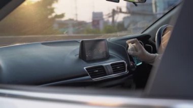 Beyaz eldiven el dezenfekte araba iç konsol panel, ön ön cam, dezenfektan mendiller. Araba yıkama şirketini dezenfekte etmek, Covid19 Corona virüsü, yeni normal araba yıkama günbatımı altın saati.