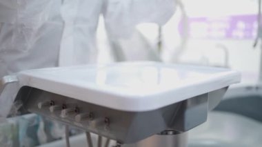 Diş malzemelerini ambalajlayan beyaz PPE takımlı hemşire kadrosu, diş ameliyatından önce dezenfekte edilmiş hazırlık, profesyonel iş, steril temiz hijyen maddeleri kirlenmiş yüzey 