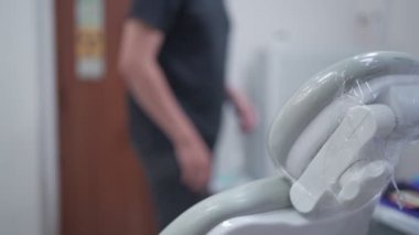 Asyalı erkek hasta diş sağlığı kliniğine giriyor ve diş hekimliği koltuğuna oturuyor. Yıllık tıbbi bakım masrafları. Kvid-19 Corona virüsü sırasında kostüm, diş tedavisi, danışmanlık teşhisi.
