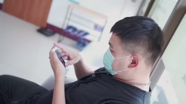 Homem Asiático Usar Máscara Cirúrgica Cabeça Para Baixo Rolagem Telefone — Vídeo de Stock