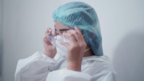 亚洲女护士身穿白色Ppe西服 医用防护服 防护眼镜 N95口罩和面罩大流行病Covid Corona病毒 在诊所进行传染病预防 — 图库视频影像