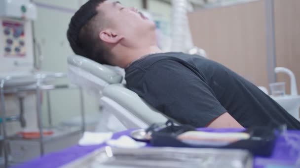 Uomo Asiatico Sdraiato Sulla Sedia Dentale Lentamente Reclinabile Trattamento Medico — Video Stock