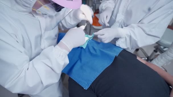 在男病人手术 牙科手术室 医生穿白色Ppe西服 医疗外科设备 消毒设备 外科口罩 传染病预防等方面开展工作的牙科医生小组 — 图库视频影像