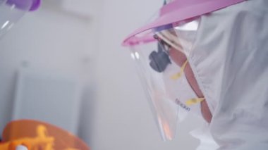Diş hekimi ve hemşire kadrosu, diş kliniğinde oral ameliyat sırasında bez kaplı yüzü olan hasta üzerinde çalışıyor, Ppe giysi koruyucu maske yüz kalkanı, covid-19 Corona virüs koruması.