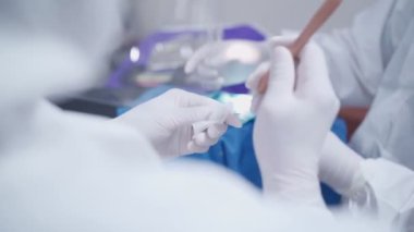Diş hekimi asistanı hazırlığı ve diş hekimliği aracı dişçiye, yeni normal konsept ve teknolojiyle çalışıyor, bulaşıcı hastalık riski, koruyucu maskeli doktor ve tıbbi gözlüklü doktor
