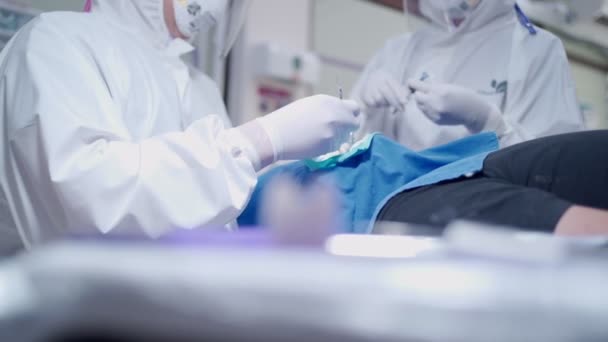 牙科医生手术室 男病人 工作卫生消毒程序 牙科医生及助理护士戴口罩 护目镜 防护手套 医疗器械 传播病毒 — 图库视频影像