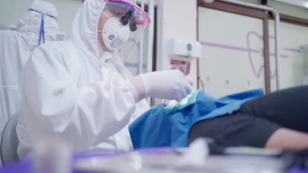 Aziatisch Professioneel Tandartsteam Volledig Virus Beschermend Uniform Zitten Door Patiënt — Stockvideo