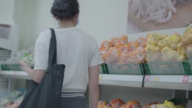 Süpermarkette çantalı bir kadının arka planı.