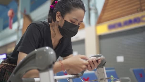 Jovem Fêmea Usar Máscara Protetora Preta Usando Telefone Inteligente Inclinando — Vídeo de Stock
