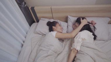 İki kadın lezbiyen çift yatağa uzanıyor, birbirlerine bakıyorlar, kafa çekiyorlar, LGBTQI, Gurur Etkinliği, bağlanma ilişkisi, rahat yatak odası ve sıcak battaniye, uyumadan önce mutluluk.