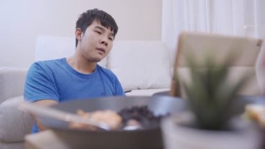 Asyalı genç adam boş cüzdan kredi kartı faturalarına bakıyor, para harcama problemi, apartmanın içinde yere oturuyor, mutsuz duygular, para krizi, işsiz boş tasarruf hesabı