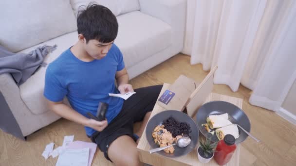 年轻的亚洲男人看着空空的皮夹 信用卡帐单 货币支出问题 坐在公寓里的地板上 货币金融危机 贫困金融业破产的概念 — 图库视频影像