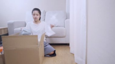 Gençlerin karton kutuya bir şeyler koyması, taşınmaya hazırlanması, arka planda kanepeye oturması, birden fazla iş yerinin düzenlenmesi, finansal krizin yeniden düzenlenmesi, evde kalmanız.