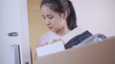 Karton kutu taşıyan genç Asyalı kadın yeni daireye giriyor, kahverengi karton kutu konteynır, ev kredisi, yeni odaya taşınma, depo teslimatı, bekar kadın.