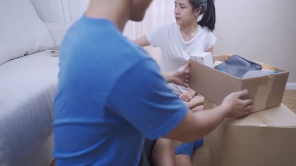 Junges Asiatisches Paar Sortiert Sachen Aus Dem Paketkasten Setzt Sich — Stockvideo