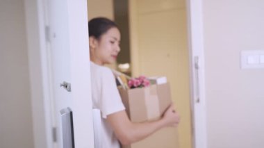 Genç, Asyalı bir kadın yeni daireye giriyor, kahverengi karton kutu, ev kredisi borcu, yeni bir daireye taşınma, yeni bir eve taşınma, depo alanı, bekar kadın yaşam tarzı.